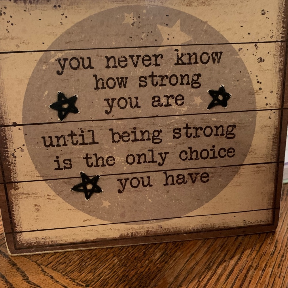 Inspirational saying on wood sign with woven stars and stars in the wood.